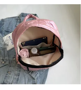 Detailed interior of pink quilted backpack showing spacious main compartment with essentials