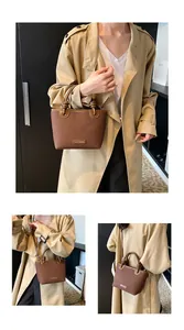 Detailaufnahme der braunen Beuteltasche mit Knotengriff und goldenem Markenschild aus Leder