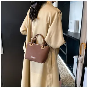 Details der Vintage-Eimertasche mit Knotengriff und goldenem Logo-Schild