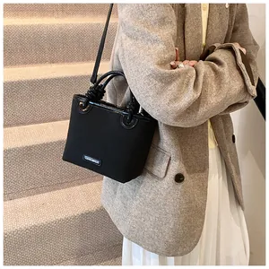 Detailansicht der schwarzen matten Beuteltasche mit Ledergriffen in einer Lifestyle-Umgebung