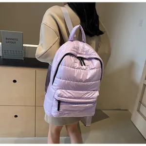 Close-up of lightweight quilted lavender puffer backpack with metallic sheen on model