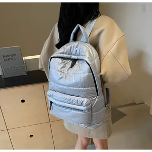 Rear view of silver puffy quilted backpack showing the large capacity and padded straps