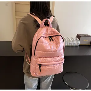 Detailed close-up of a pink quilted puffer backpack with soft padded texture and zippers