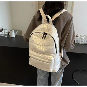 Detail view of white quilted space cotton backpack with metallic finish and zip outer pocket