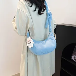 Light blue quilted dumpling bag with adjustable knotted strap and rabbit pendant