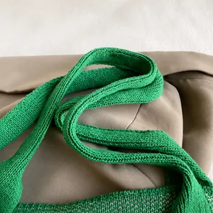 Détail de la bandoulière en tricot vert herbe avec une texture de laine épaisse