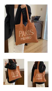 Detalle de bolso tote de punto color caramelo con letras de Paris Milano y textura