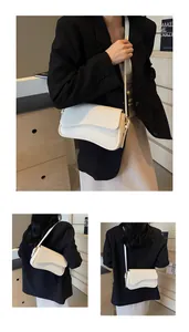Detail view of cream white litchi pattern leather crossbody bag with flap and strap