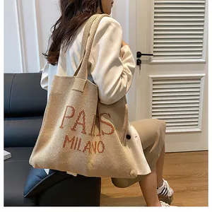 Detalle del bolso tote de punto con bordado PAIS MILANO y textura de punto suave