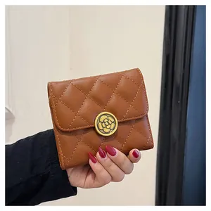 Vue détaillée du portefeuille marron en cuir matelassé avec boucle fleur de camélia dorée