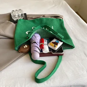 Bolso tote de punto verde para mujer que muestra un interior espacioso con artículos diarios