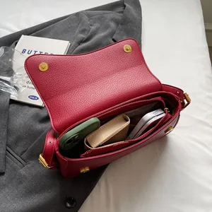 Retro red lychee leather crossbody bag with gold buckles and spacious interior