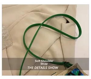 Détail de la bandoulière en cuir vert souple et sequins sur un sac à main chic