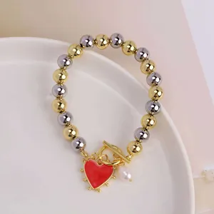 Detail of 18K gold plated OT clasp bracelet with red heart charm and pearl drop