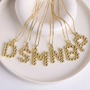 18K gold-plated initial necklaces with 3D balloon-style letters D S M N B P on a tray