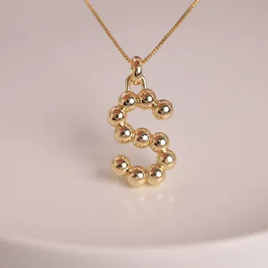 Detailed view of the 18K gold plated S-letter balloon pendant with rounded metal beads