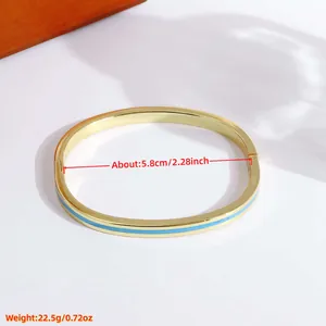 18K gold plated copper bangle with light blue enamel inlay and a hinged clasp design