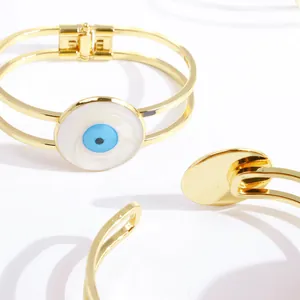 Detail eines 18K vergoldeten Doppelband-Federarmbands mit blauem Evil Eye Talisman