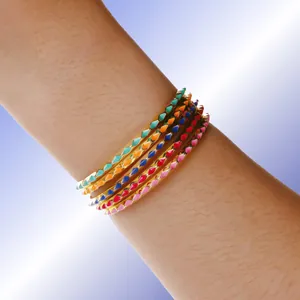 Set aus fünf 18K vergoldeten Armreifen mit bunten Emaille-Spikes an weiblichem Modell