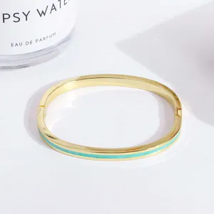 Close-up of 18K gold plated copper bangle with turquoise enamel inlay and hinge detail
