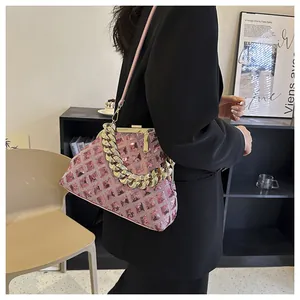 Détail du sac à main rose à paillettes avec poignée en chaîne dorée et fermoir en métal