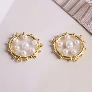 Macro view of 18K gold plated charms with small gold beads and white faux pearl inlay