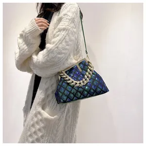 Détail d'un sac à paillettes avec chaîne dorée et texture à carreaux dégradés