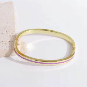 Close-up of 18K gold plated bangle featuring purple enamel inlay and a side hinge clasp