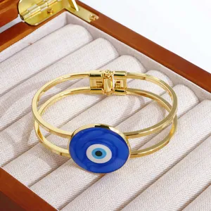 Detailansicht des 18K vergoldeten Evil Eye Armreifs auf einem Schmuckkasten aus Samt