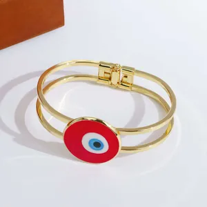 Detailansicht des 18K vergoldeten Doppelspur-Armreifs mit farbigem Evil Eye Anhänger