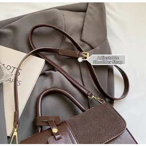 Detalle de bolso de mano marrón tipo patchwork con correa ajustable y herrajes dorados