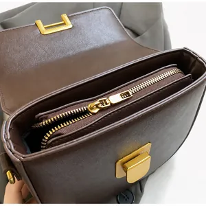 Dettaglio della cerniera in metallo dorato e l'interno in pelle marrone scuro borsa