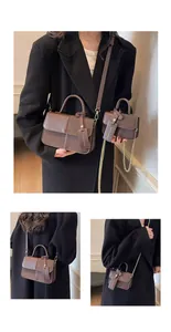 Bolso vintage marrón oscuro con costuras verticales y detalle de cadena dorada