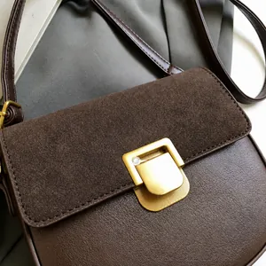 Dettaglio della fibbia in metallo dorato opaco su borsa in pelle marrone vintage