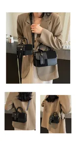 Detalle del bolso bandolera de cuero negro con cadena de metal y colgante de moda actual