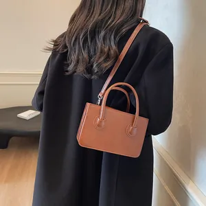 Borsa a tracolla rettangolare marrone in pelle PU con doppi manici indossata da una modella