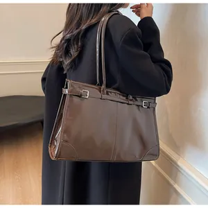 Detailed side view of high-gloss dark brown tote bag with decorative buckle strap