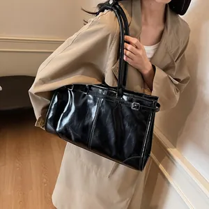 Black glossy wax leather tote bag for women shown with a long shoulder strap