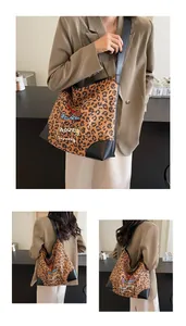 Detail of leopard print tote bag featuring three cute cartoon dogs and black straps