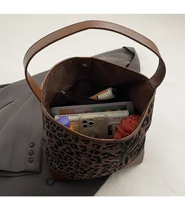 Top view of spacious leopard print tote interior with brown leather strap and magnetic closure