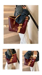 Detail of burgundy tote bag with woven texture and a cute brown plush bear charm