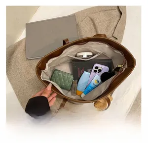 Top view of large brown tote bag showing spacious interior with zipper pocket and daily items