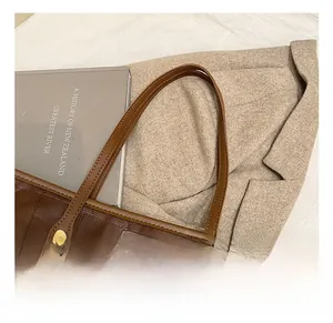 Detailed macro view of dark brown woven tote bag with a golden stud and cute bear charm