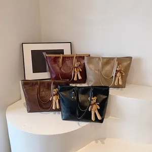 Chic geometric textured tote bags in four colors with cute bear charms on display