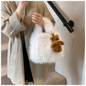 Detail of soft white faux fur tote bag with a cute brown plush bear charm and pearl necklace