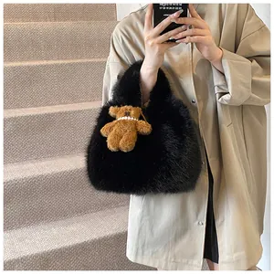 Detail of black faux fur tote bag with a cute bear pendant on a beige coat background