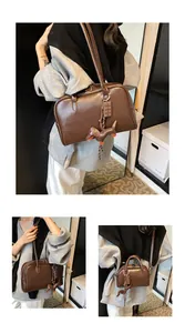 Detail of dark brown retro bowling bag with dachshund charm and matte leather texture