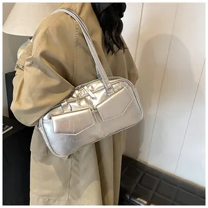 Detalle del bolso de hombro plateado metalizado con acabado plisado y bolsillos dobles