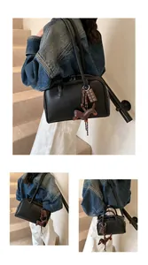 Detail of black matte leather bowling bag with brown horse and chocolate charms
