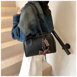 Detail of black leather bowling bag with creative horse and chocolate charms